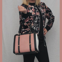 Black handbag with pink panel and grab handle
