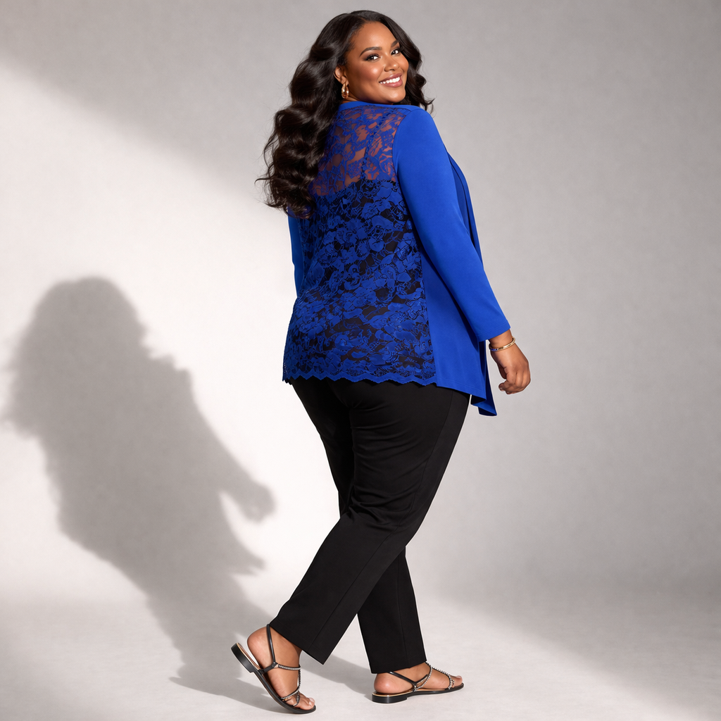 Woman wearing a blue lace top and black pants against a gray background