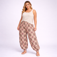 Woman wearing a white sleeveless top and patterned pants on a white background