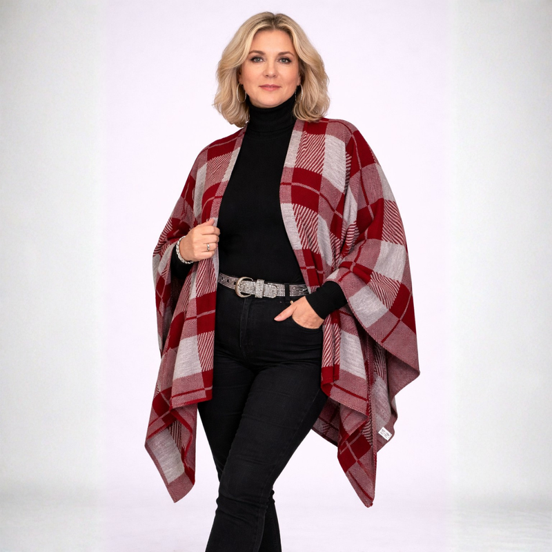 Woman wearing a red and gray plaid shawl over a black outfit on a white background