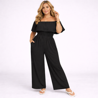 Woman wearing a black off-shoulder jumpsuit on a white background