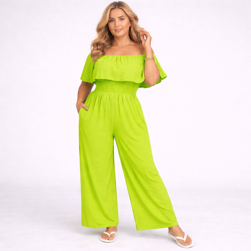 Woman wearing a bright green off-shoulder jumpsuit on a white background