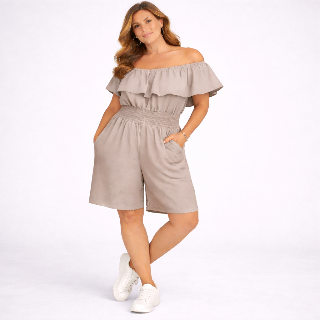 Woman wearing a beige off-shoulder romper on a white background