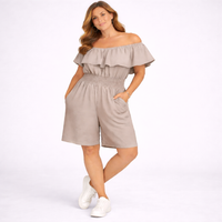 Woman wearing a beige off-shoulder romper on a white background