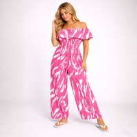 Woman wearing a pink and white tie-dye jumpsuit on a white background