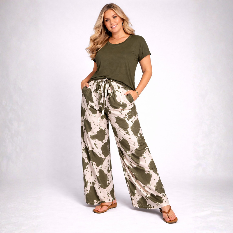 Woman wearing a green top and camouflage pants on a white background