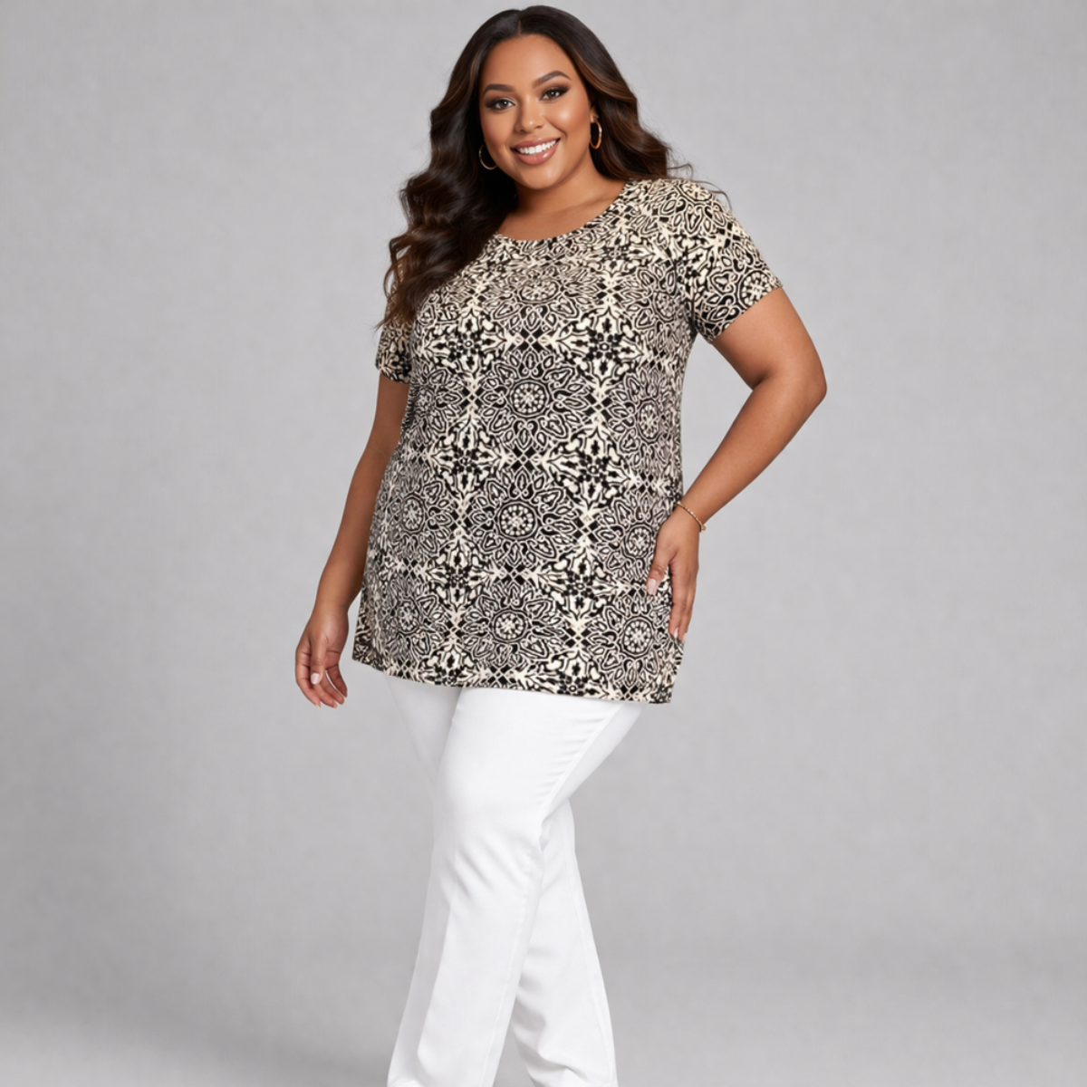 Woman wearing a patterned top and white pants on a gray background