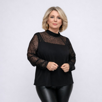 Woman wearing a black top with sheer sleeves against a white background