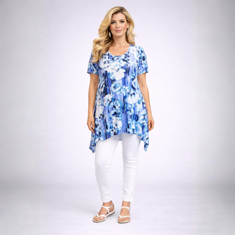 Woman wearing a blue floral dress and white pants on a gray background