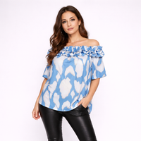 Woman wearing a blue and white patterned off-shoulder top on a white background