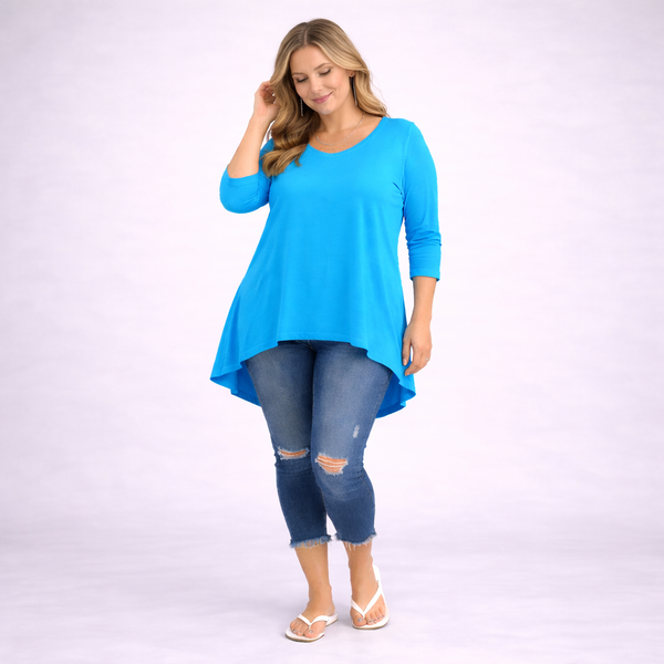 Woman wearing a blue top and jeans on a white background